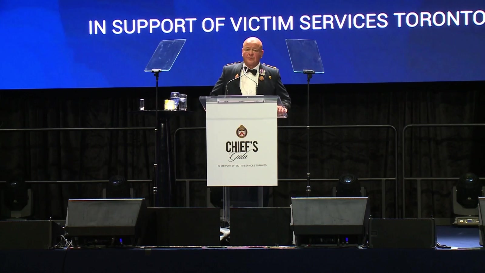 A speaker at a podium on stage at the Chief's Gala, in support of Victim Services Toronto
