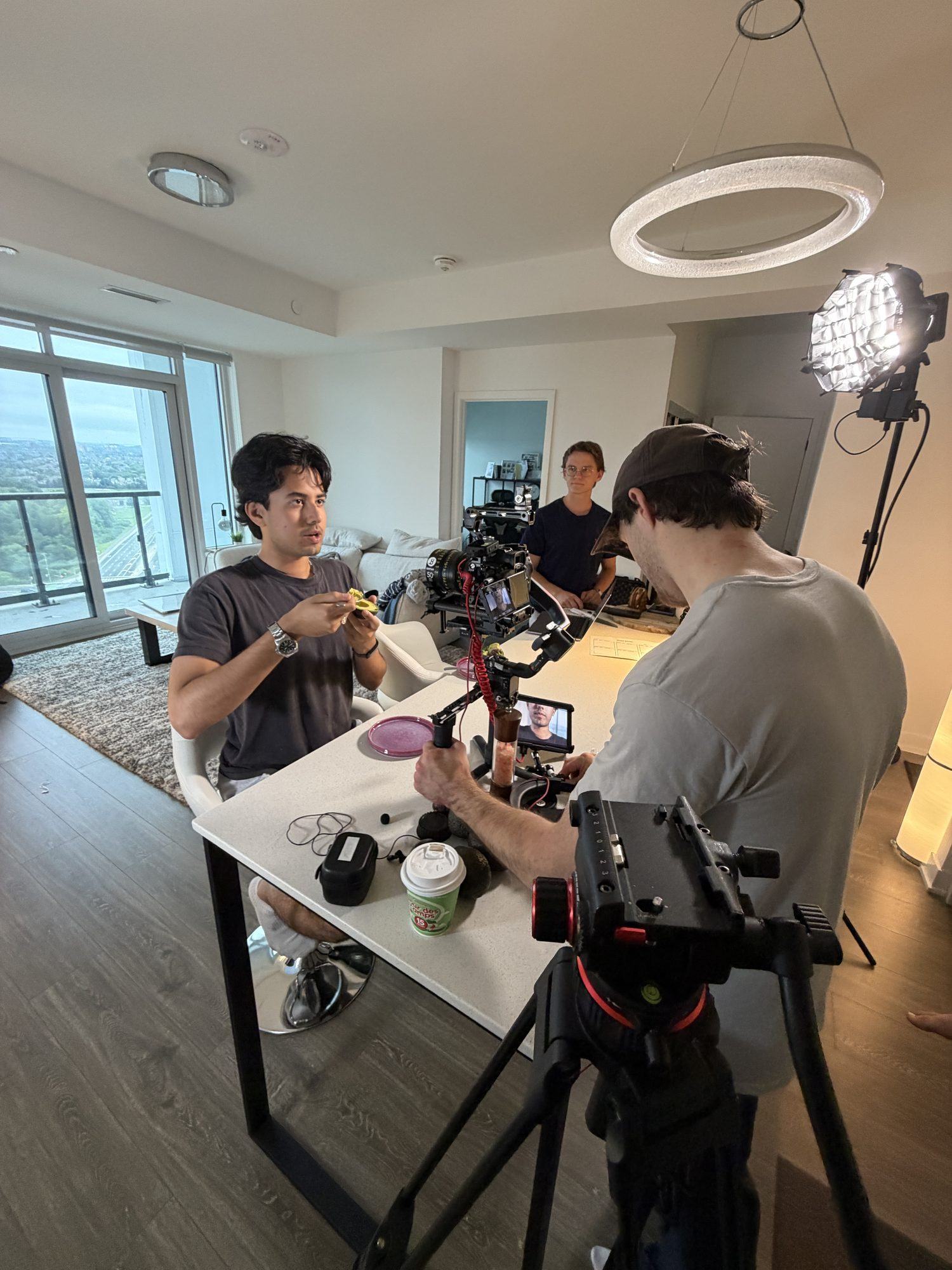 Crew preparing a camera on a gimbal around a table in a bright apartment